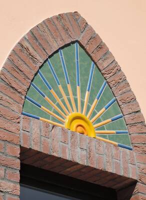 Sunburst Arch: Terracotta Façade with Mosaic Panel