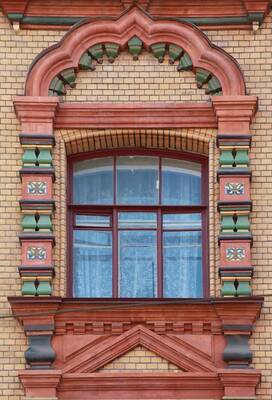 Art Nouveau arched window with terracotta decoration on a brick façade