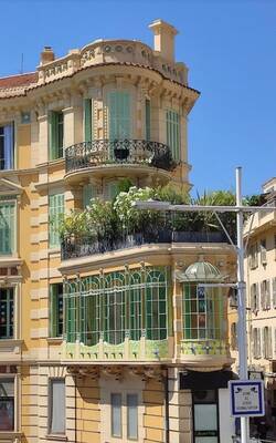 Elegant Mediterranean facade with curved balconies and green accents