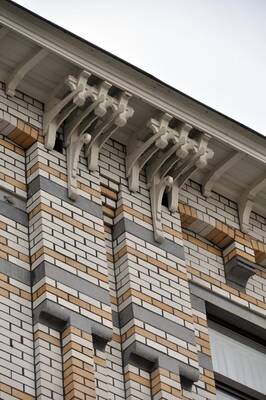 Polychromatic Brick Facade with Decorative Wooden Brackets