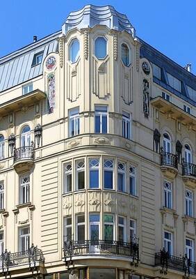 Elegant Corner Façade of a Neoclassical Building with Bay Windows and Decorative Elements