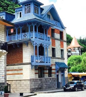 Eclectic façade with balconies: a combination of stone, brick, and openwork wood