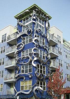 Expressive Metal Facade: Blue Tower with Dynamic Sculptural Composition