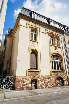 Elegant Art Nouveau: A Facade with Flowing Lines and Stone Foundation