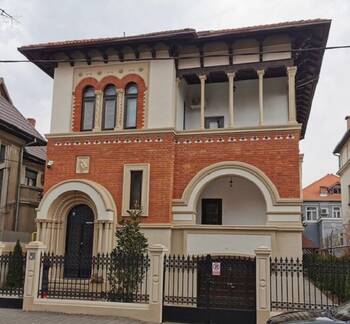 Eclectic mansion facade with neoclassical elements: combination of brick and light plaster