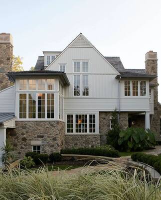 Elegant country house with contrasting facade of stone and light vertical cladding