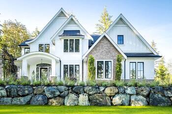 Modern Farmhouse Facade: Harmony of White Siding, Brick, and Stone