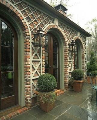 Elegant brick facade with arched windows and decorative wooden lattice