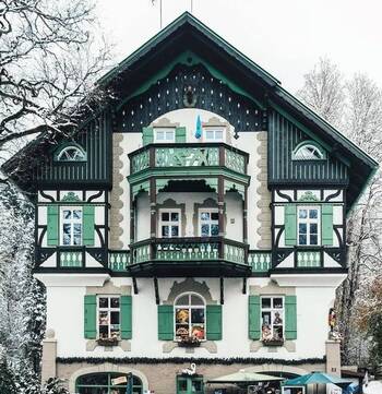 Alpine Elegance: Green and White Facade of a Chalet-Style Mansion