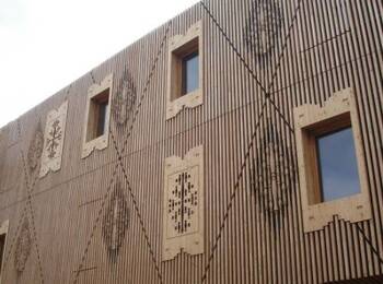 Modern wooden facade with vertical lamellas and decorative panels