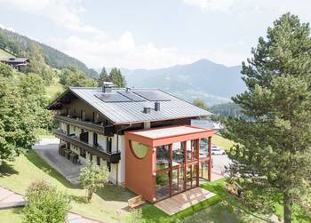 Modern Alpine chalet with contrasting terracotta facade extension and eco-friendly solutions