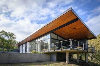 Modern facade with wooden cantilevered roof: minimalism in harmony with nature