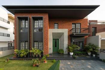 Modern brick facade with contrasting elements and green accent