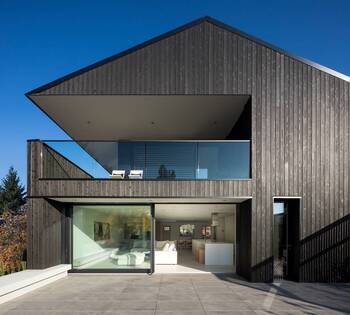 Modern minimalist facade with wooden cladding and cantilevered extension