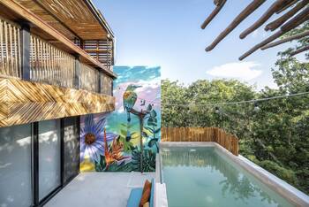 Tropical facade with natural materials and artistic mural in harmony with nature