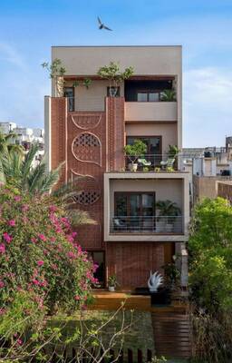 Modern urban house with decorative brick facade and green terraces