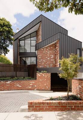 Two-level house with contrasting façade: combination of brick and metal panels