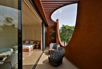 Organic facade with curved lines: terracotta terrace with oval opening