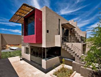 Modern house with accent burgundy facade and wooden pergola