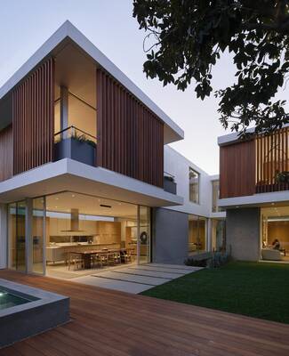 Contemporary minimalist facade with wooden louvers and contrasting volumes