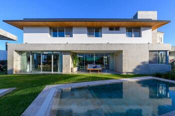 Modern two-story house with a contrasting facade of concrete and light plaster