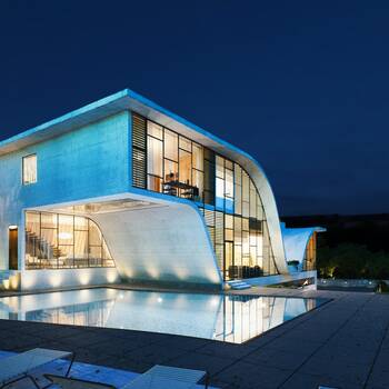 Wave-shaped concrete facade of a modern mansion with panoramic glazing