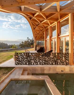 Panoramic wooden facade with curved roof and decorative railing