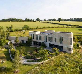 Modern minimalist country house with stone facade amid natural landscape