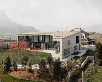 Modern mountain residence with stone facade and panoramic glazing