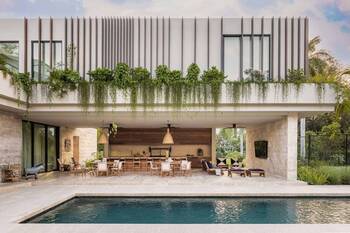 Modern Tropical Facade with Vertical Louvers and Cascade Greenery