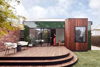 Modern house with a contrasting facade of green tiles and wooden panels