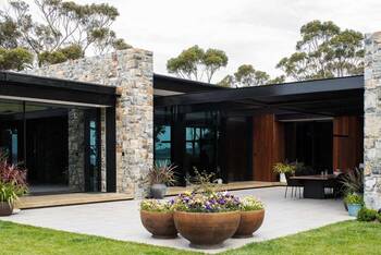 Modern country house with contrasting stone and glass facade