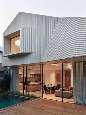 Modern house with dynamic slatted facade and contrast between closed upper volume and open lower level