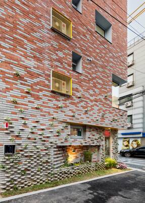 Eco-friendly brick façade with integrated greenery and contrasting accents