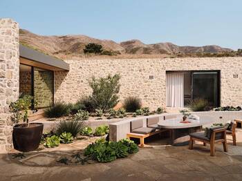 Stone facade of a modern house in desert landscape: synthesis of nature and architecture