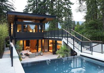 Modern two-level house with minimalist facade surrounded by forest