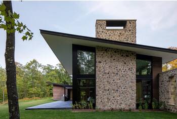 Modern country house with contrasting stone and glass facade