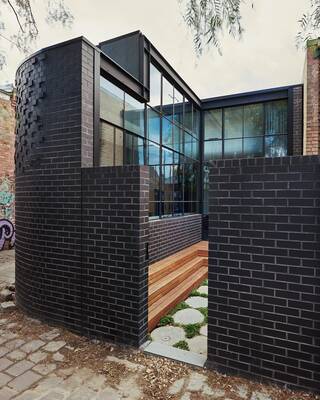 Modern minimalist facade with contrasting combination of dark brick and glass