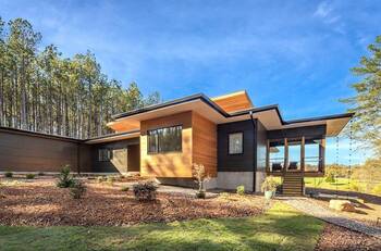 Modern country house with a contrasting facade of wood and dark panels