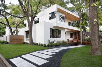 Minimalist White Facade with Wooden Accents in Green Surroundings