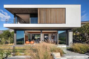 Minimalist house with wooden slats on the façade in a mountain landscape