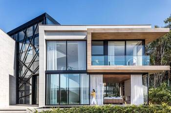 Modern villa with contrasting facade: synthesis of glass, stone and wood