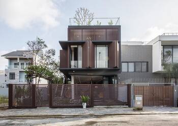 Modern three-story house with expressive wooden facade and rooftop garden