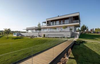 Modern minimalist facade with cantilevered projection: harmony of concrete, wood and glass on a slope