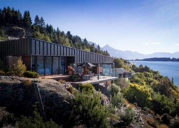 Modern house with metal facade on a mountainside with panoramic lake views