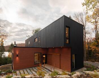 Contrasting Two-Volume Façade: Combination of Dark Wood and Copper-Red Metal in a Modern Forest House