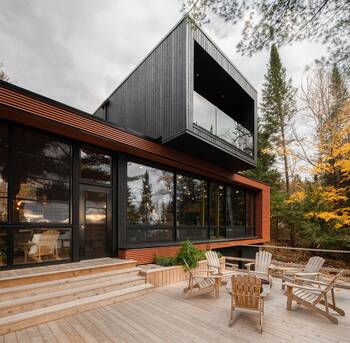 Modern countryside house with contrasting wooden facade and cantilevered second floor