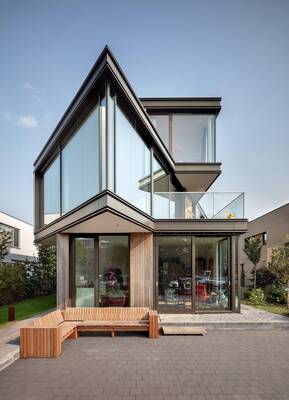 Modern house with dynamic glass facade and wooden cladding