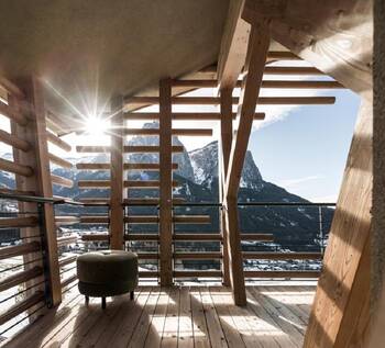 Alpine terrace with wooden slatted facade and panoramic mountain view