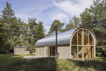 Modern house with arched facade in forest surroundings